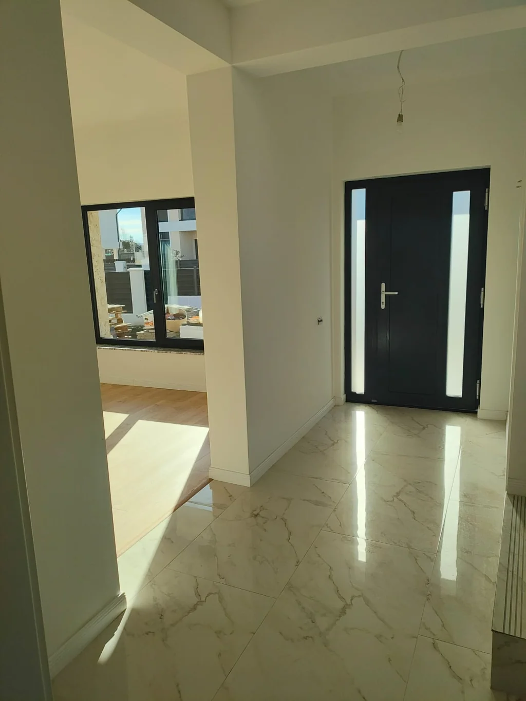 Hol de intrare casă finisată cu gresie și ușă modernă Iași
